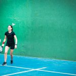 a woman standing on a tennis court holding a racquet